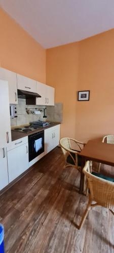 uma cozinha com uma mesa e um fogão forno superior em Pension Valeria em Plauen