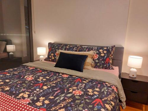 a bedroom with a bed with a floral comforter and two lamps at Stylish 1 bedroom best location in Sydney