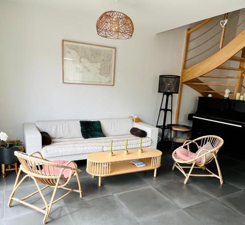 - un salon avec un canapé, deux chaises et un piano dans l'établissement Maison au calme/ Plage 10 min à pied WIFI /5 pers, à Carnac