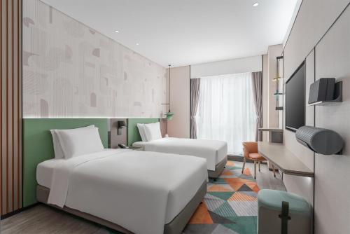 een hotelkamer met 2 bedden en een televisie bij EVEN Hotel Zhongshan City Center, an IHG Hotel in Zhongshan