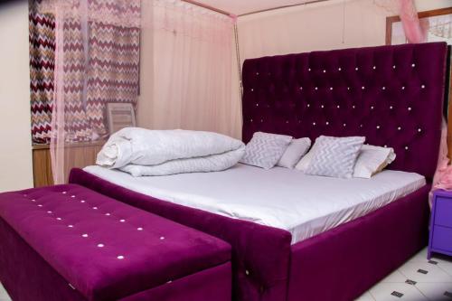 a bedroom with a purple bed and a purple bench at Denverwing Homes in Eldoret