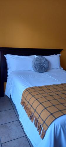 Una cama con sábanas blancas y una almohada. en Platinum gem in the City of Rustenburg en Rustenburg
