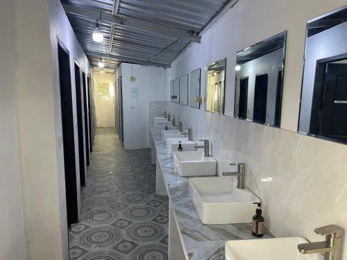 La salle de bains est pourvue d'une rangée de lavabos et de miroirs. dans l'établissement Top One Backpacker Hostel, à Vientiane