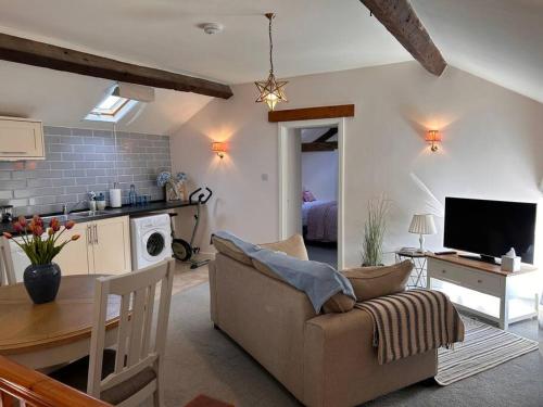 a living room with a couch and a table at The Old House Barn in Staverton