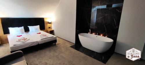 a hotel room with a bath tub next to a bed at Karczma u Jana in Kuczów