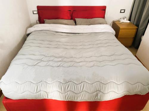 ein Bett mit einer roten und weißen Bettdecke darauf in der Unterkunft La Terrazza Bella Sicula in Furci Siculo
