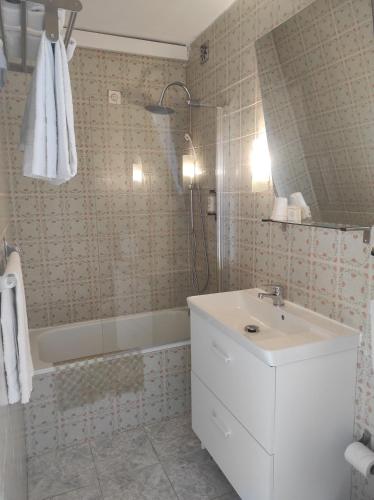 a bathroom with a white sink and a bath tub at Hotel Boavista - Vintage House in Monfortinho