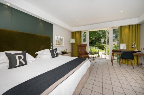 um quarto de hotel com uma cama e uma secretária e um quarto em Rudding Park em Harrogate