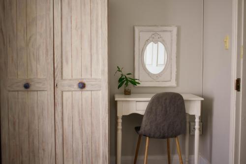 a chair sitting next to a desk with a mirror at African Sands B&B in Amanzimtoti