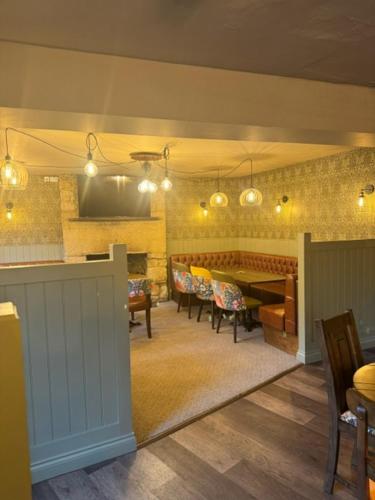 a living room with a table and chairs and a television at Britannia inn in Sherborne