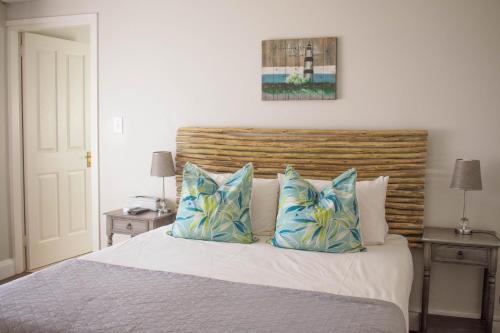 a bedroom with a bed with two blue pillows at African Sands B&B in Amanzimtoti