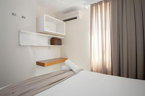 ブラジリアにあるHotel Premier Residence Brasília - Ozped Flatsの白いベッドルーム(ベッド1台、窓付)