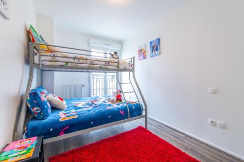 a bedroom with a bunk bed and a red rug at *SPACIOUS APARTMENT DISNEYLAND PARIS* in Serris