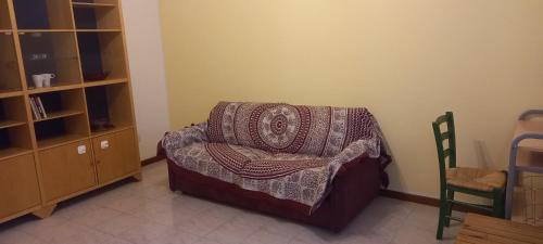 a room with a chair with a blanket on it at Zaffiro Parma in Parma