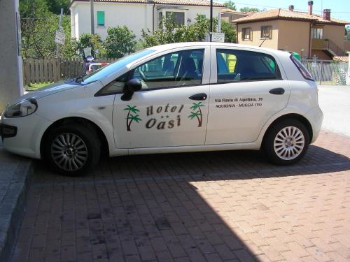 a white car parked on the side of a street at Hotel Oasi in Muggia