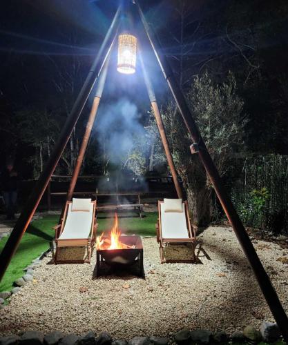 a fire pit with chairs and a camp fire at River Glamping Kalopanayiotis in Kalopanayiotis