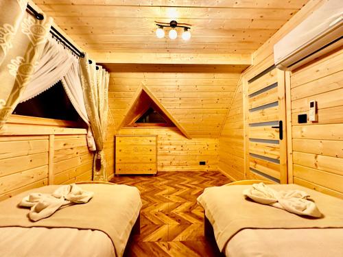 sypialnia z 2 łóżkami w drewnianym domku w obiekcie Góralska Osada Tatra House z jacuzzi w mieście Białka Tatrzanska