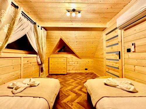 sypialnia z dwoma łóżkami w chacie z bali w obiekcie Góralska Osada Tatra House z jacuzzi w mieście Białka Tatrzanska