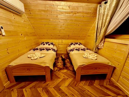 a room with two beds in a wooden room at Góralska Osada Tatra House z jacuzzi in Białka Tatrzanska