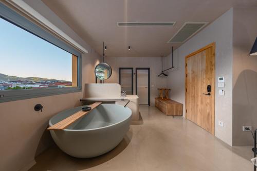 a bathroom with a tub and a large window at Roome in Fethiye