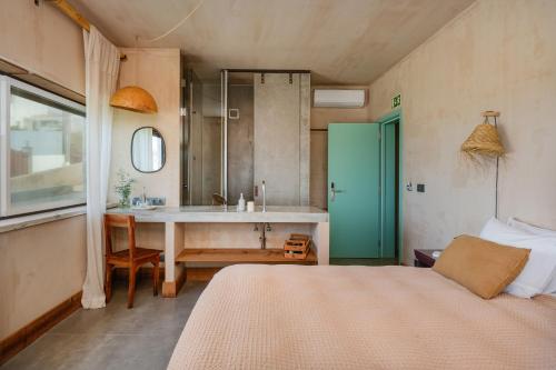 sypialnia z łóżkiem oraz łazienka z umywalką w obiekcie Azenhas do Mar Valley House w mieście Sintra