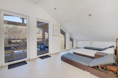 a bedroom with two beds and large windows at Luxus-Wellness-Haus am Waldsee in Rieden