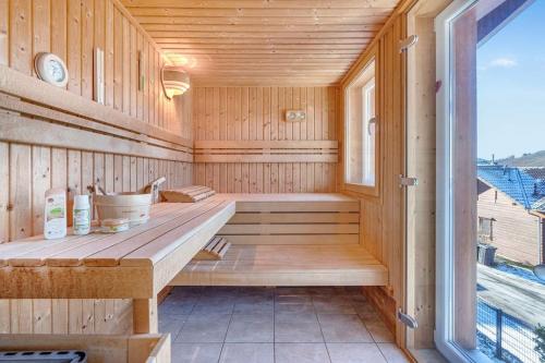 una sauna de madera con banco y ventana en Luxus-Wellness-Haus am Waldsee en Rieden