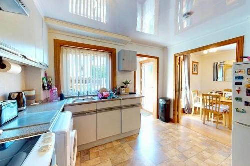 a kitchen with white cabinets and a dining room at Fort William - Highland holiday home in Fort William