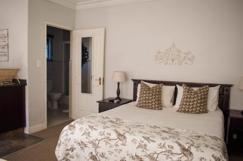 a bedroom with a large bed and a bathroom at African Sands B&B in Amanzimtoti