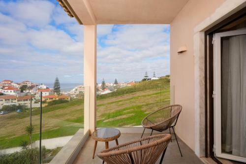 un balcone con 2 sedie e una grande finestra di Azenhas do Mar Valley House a Sintra