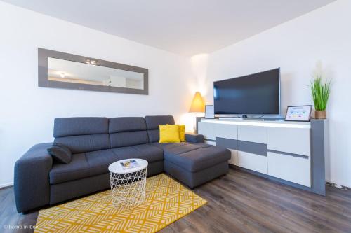 a living room with a couch and a flat screen tv at *SPACIOUS APARTMENT DISNEYLAND PARIS* in Serris