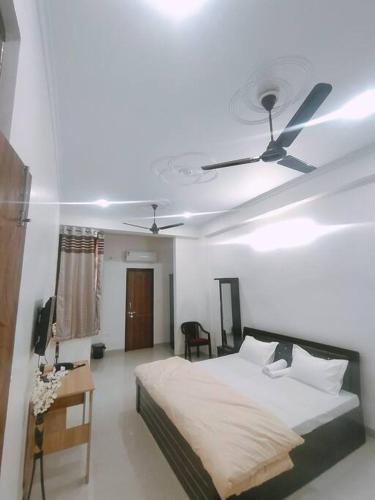 um quarto com uma cama e uma ventoinha de tecto em Bayweaver nests homestay Vishal khand 102 em Lucknow