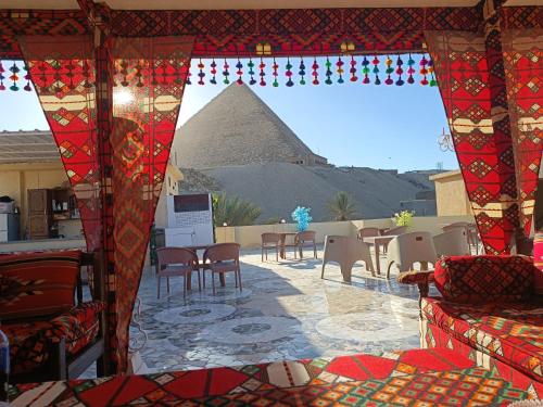 uitzicht op een piramide vanuit een kamer met tafels en stoelen bij Crystal pyramid inn in Caïro