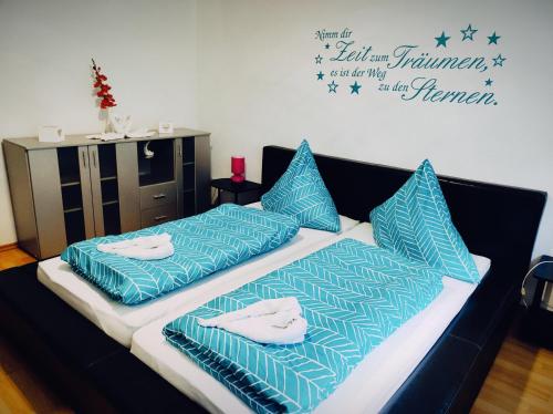 two beds with blue pillows on them in a room at Ferienwohnung im Mühlbachtal in Miehlen