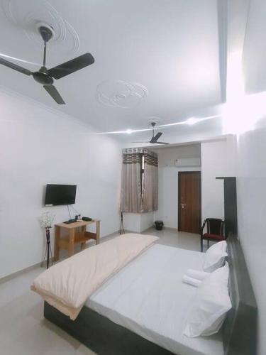 um quarto com uma cama grande e uma ventoinha de tecto em Bayweaver nests homestay Vishal khand 102 em Lucknow