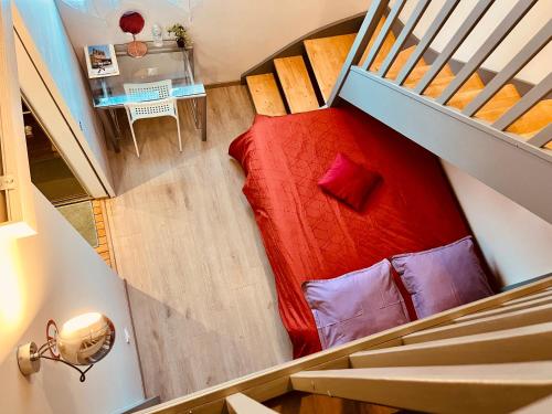 a room with a red bed and a table at Loption in Carbonne