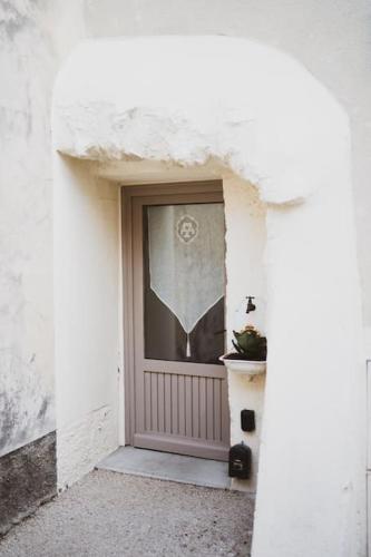 a front door of a white building with a potted plant at L'évasion de Bedoin, appartement in Bédoin