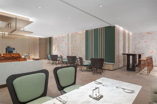 a restaurant with tables and chairs and a bar at EVEN Hotel Zhongshan City Center by IHG in Zhongshan