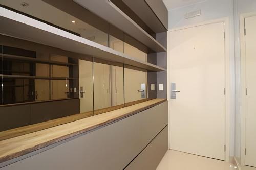 a dressing room with white cabinets and mirrors at Hotel Vision Brasília - Ozped Flats in Brasilia