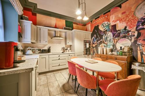 a kitchen with a white table and orange chairs at Jazz House in Derry Londonderry