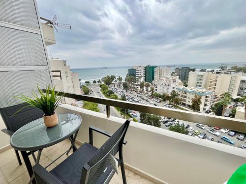 a balcony with a table and chairs and a view of a city at Enaerios SeaView Studio in Limassol