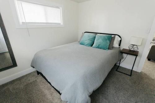 a bedroom with a bed with blue pillows and a window at Great Location in Dayton! Updated 1 bedroom/bath. in Dayton