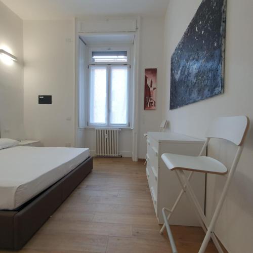 a bedroom with a bed and a desk and a chair at BnButler - Grasselli, 8 - Comfy and Newly Renovated in Milan