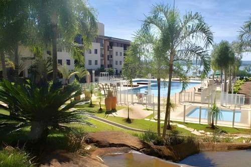 a resort with a pool and palm trees and buildings at OZPED Flats Particulares Edifício Life Resort in Brasilia