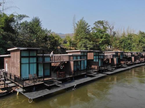 a row of houses on the side of a river at Kwai Tara Riverside Villas in Sai Yok