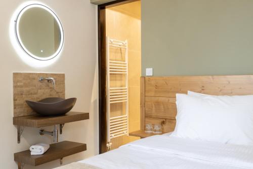 a bedroom with a sink and a bed with a mirror at Hotel Katafigio in Elati Trikalon