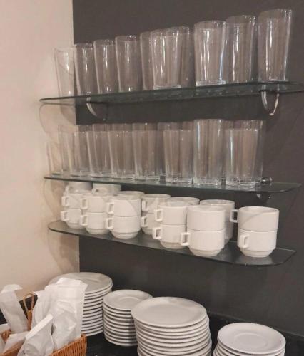 a bunch of plates and cups on a shelf at Boulevard Park Hotel in São Luís