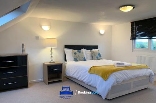 um quarto com uma cama e uma cómoda com um candeeiro em 6 Bedroom House by Beds Away Short Lets & Serviced Accommodation Oxford With 2 En-suites, Garden & Free Parking em Oxford