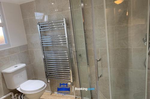 a bathroom with a toilet and a glass shower at 6 Bedroom House by Beds Away Short Lets & Serviced Accommodation Oxford With 2 En-suites, Garden & Free Parking in Oxford