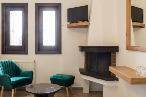a living room with a fireplace and a green chair at Hotel Katafigio in Elati Trikalon